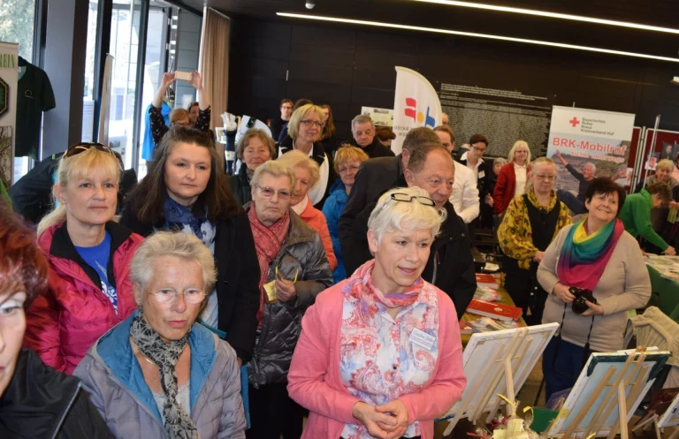 Besucherinnen und Besucher verfolgen eine Vorführung an Infoständen beim Aktionstag