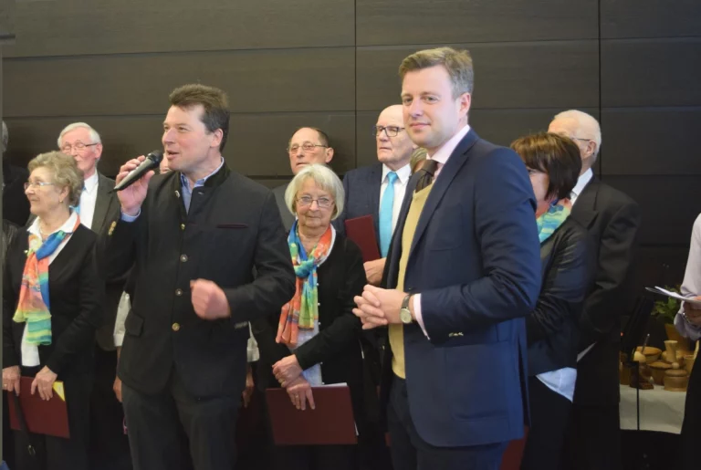 Mann mit Mikrofon spricht vor einer Gruppe von Personen beim Aktionstag