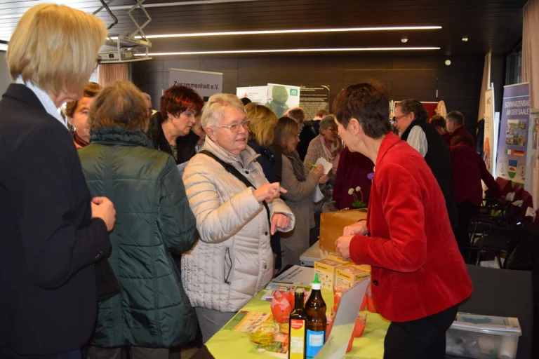 Besucherinnen und Besucher stehen an Infoständen beim Aktionstag im Gespräch mit Ausstellenden