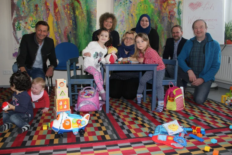 Kindergarten-Alltag zum Ausprobieren bietet das Bundesprogramm "Kita-Einstieg" unter anderem im Helmbrechtser Kreisel an (hinter den Kindern von links): Kreisjugendamtsleiter Gerhard Zeitler, Kreisel-Koordinatorin Pia Haßmann, die Erzieherinnen Tanja Herold und Mine Gumustekin-Jaballah, Andreas Buheitel von der Diakonie Hochfranken und Hans Eckert, Koordinierungsstelle Kita-Einstieg im Landkreis Hof. Foto: Kaupenjohann