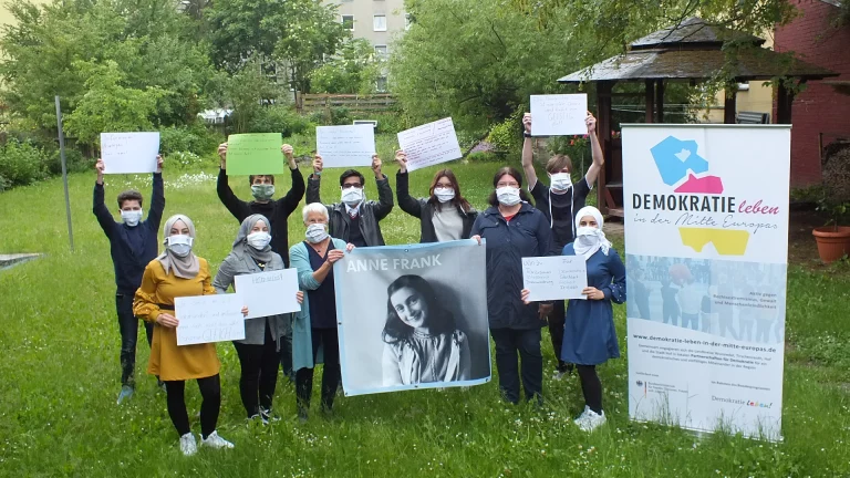 Das Bild zeigt die Peer Guides und die beiden Organisatorinnen mit einem Foto von Anne Frank (Foto: Stefan Denzler)