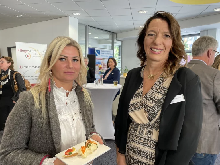 Zwei Frauen im Gespräch bei einer Veranstaltung zur Pflege im Hofer Land, mit Fingerfood