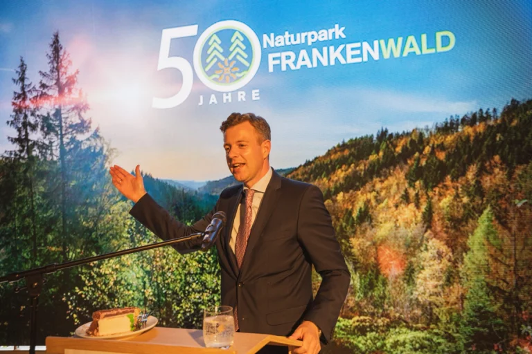 Mann am Rednerpult vor Leinwand mit Schriftzug „50 Jahre Naturpark Frankenwald“