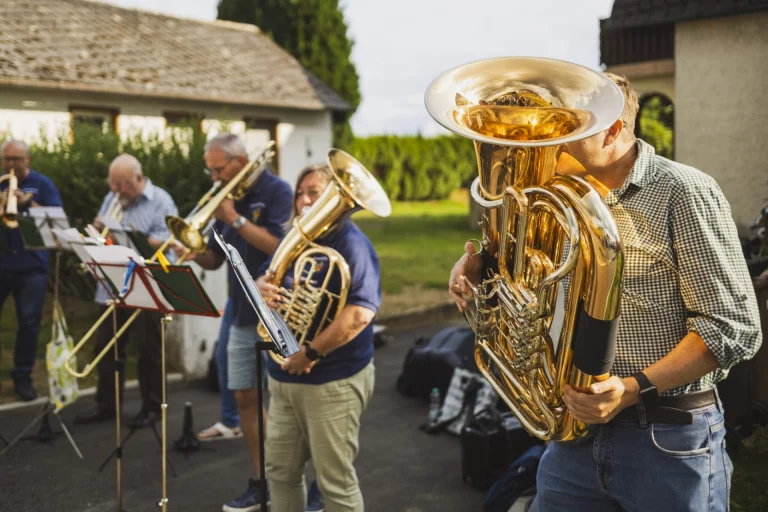 Musikkapelle mit Blechblasinstrumenten spielt im Freien bei der Einweihungsfeier