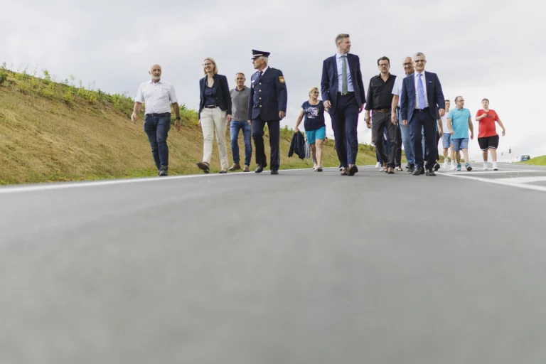 Gruppe von Personen geht gemeinsam über die neu errichtete Kreisstraße