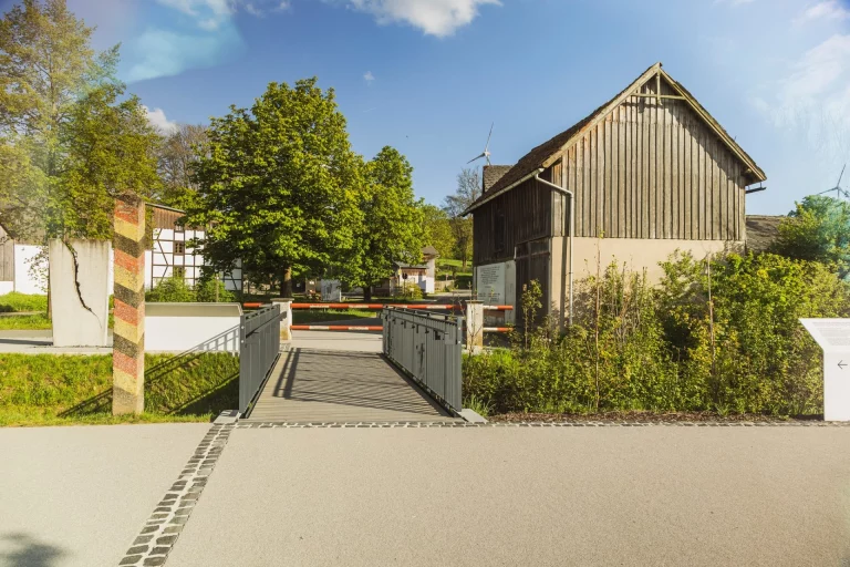 Zugangssteg über die ehemalige Grenzanlage zum Museumsgelände Mödlareuth mit Wachturm und Scheune