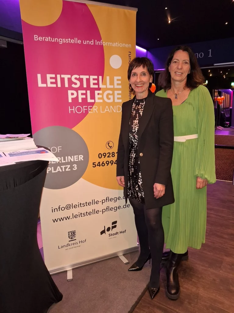 Zwei Frauen vor Roll-up der Leitstelle Pflege Hofer Land im Kinosaal