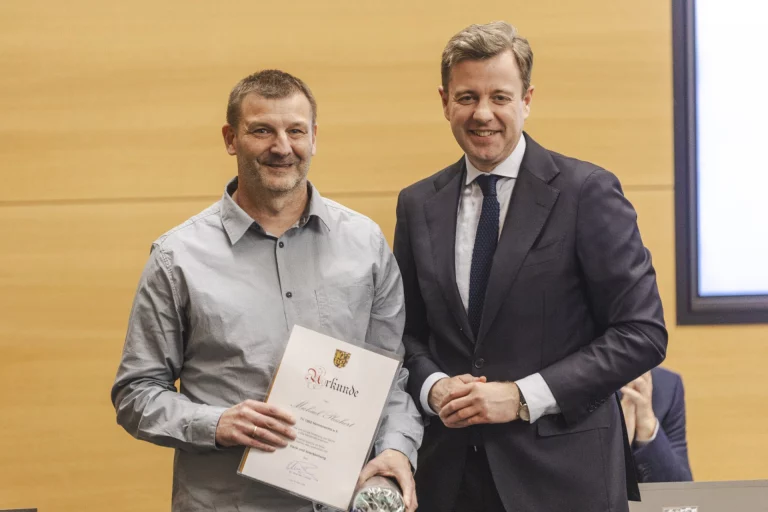 Mann mit Urkunde und Pokal neben Landrat bei Ehrung von Vereinsfunktionären