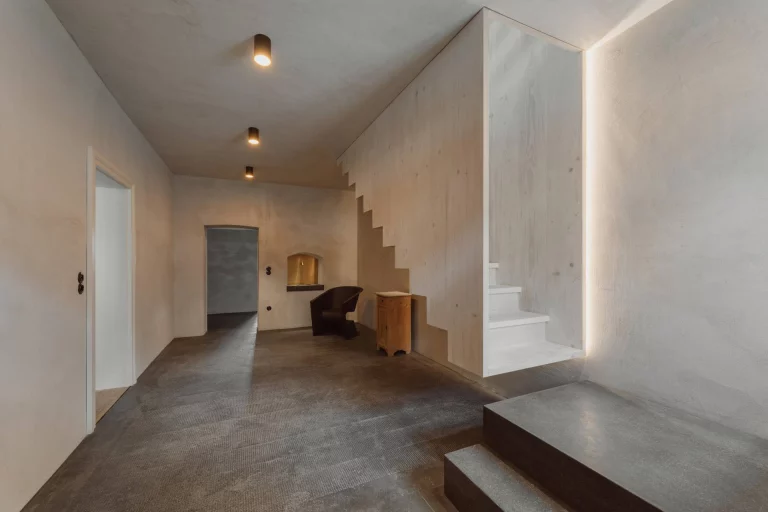 Sanierter Flurbereich mit Treppe, Terrazzoboden und indirekter Beleuchtung